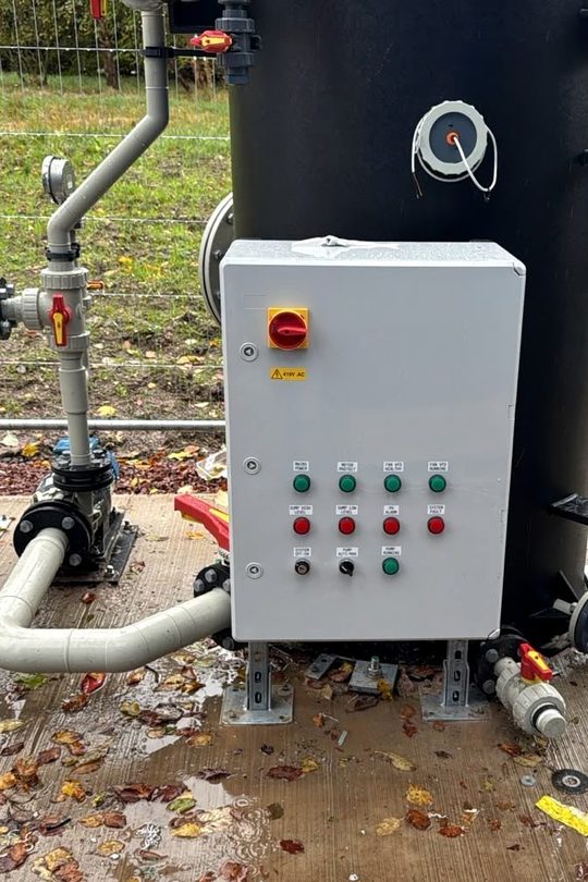 Scrubber control panel and recirculation pump at the base of the tower